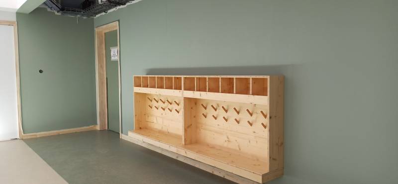 Casiers sur mesure avec patères en bois massif, bancs intégrés et zones personnalisables. Un mobilier pensé pour faciliter l’autonomie des enfants à l’entrée des classes.
