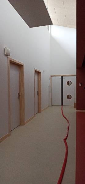  Portes bois pleine âme avec oculus, conformes aux normes ERP (résistance au feu, acoustique, PMR). Un couloir lumineux au design sobre et fonctionnel