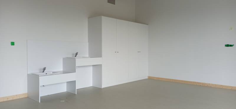 Plans vasques adaptés aux enfants de différentes tailles, complétés par de grands placards pour le rangement du matériel pédagogique.