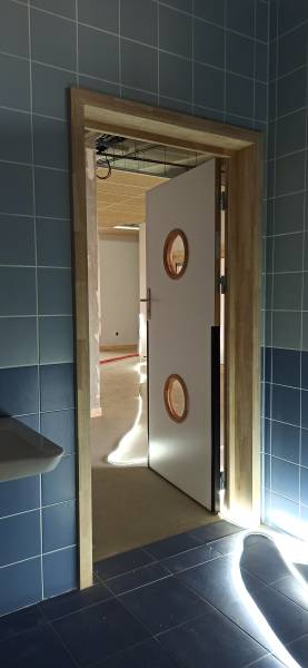  Porte avec oculus double, stratifiée et équipée de joints anti pince-doigts. Une continuité visuelle et fonctionnelle entre les zones d’usage, avec finitions soignées.